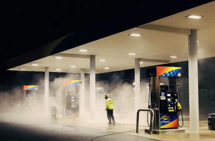 man in yellow jacket standing near gas pump